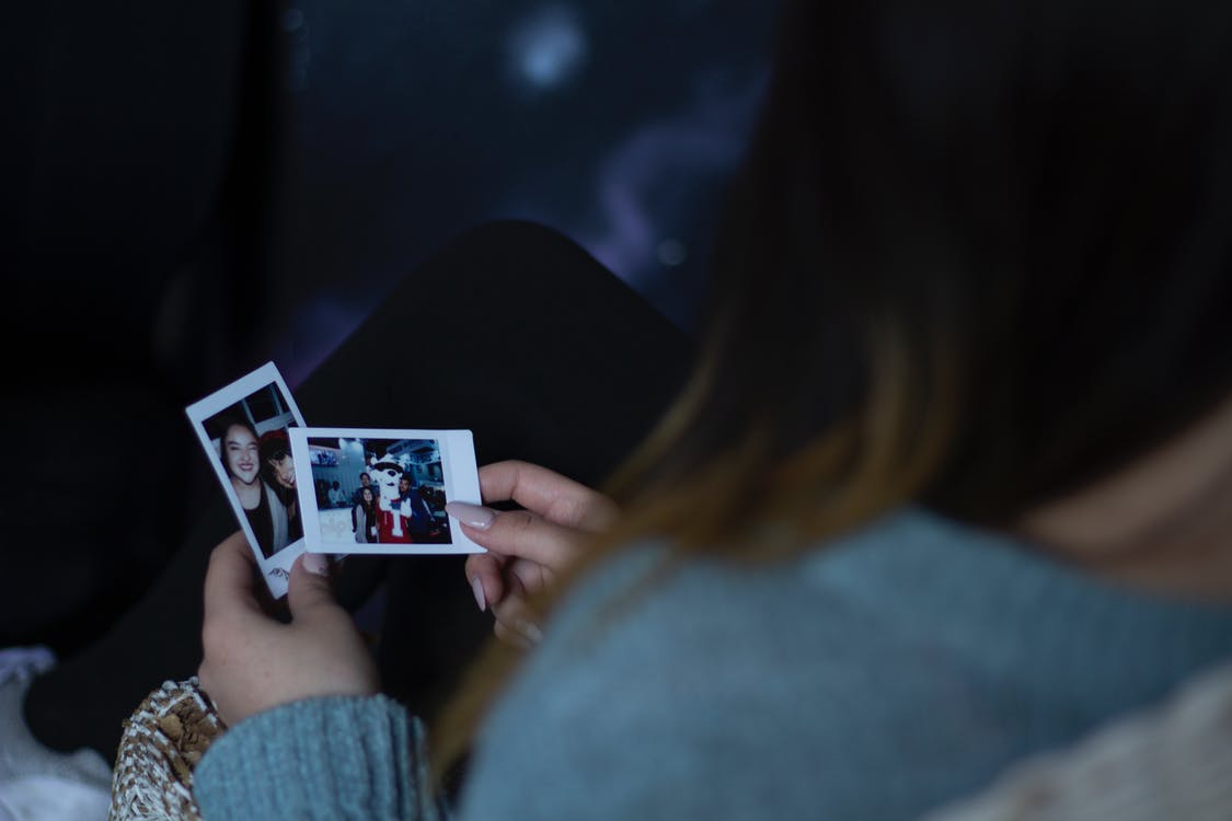 Mujer Sosteniendo Dos Fotos